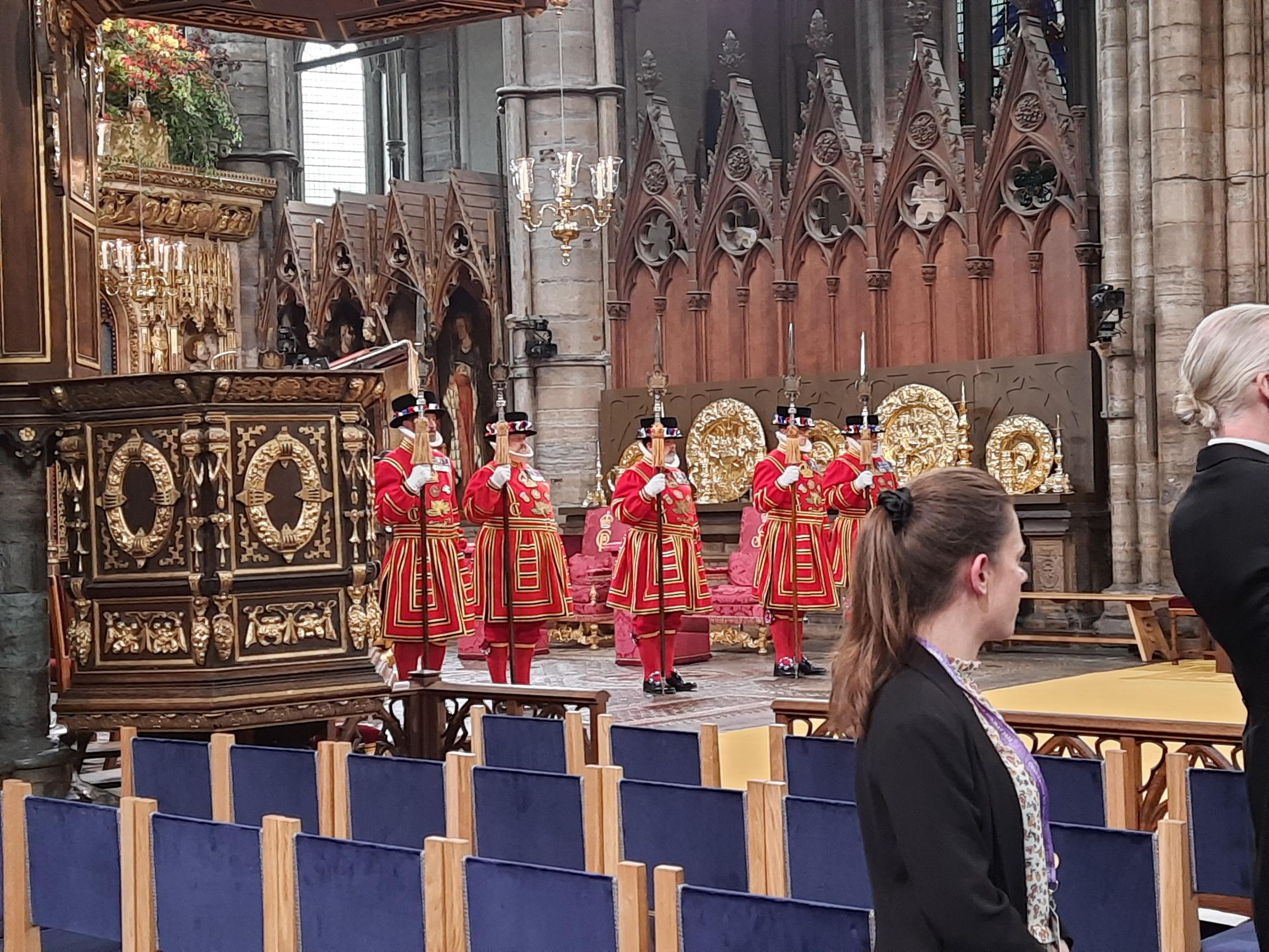 A picture of five yeoman, dressed in red uniforms holding tall spears, guarding a section of Westminster Abbey that was to be the main section used for the Coronation of King Charles III